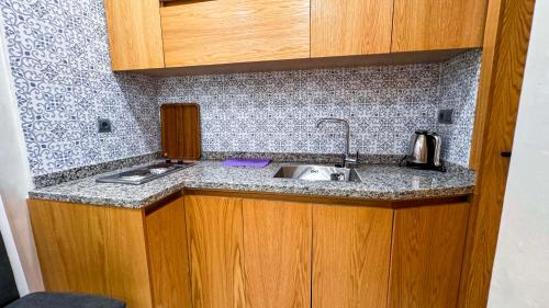 een keuken met een spoelbak en een aanrechtblad bij RESIDENCE MH HOTEL in Laayoune
