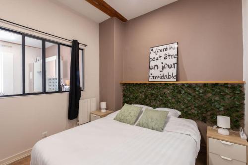 a bedroom with a white bed and a window at L'immeuble Carnot in Tournus