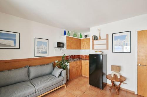 ein Wohnzimmer mit Couch und Küche in der Unterkunft Horta III - Loft - Cadaqués in Cadaqués