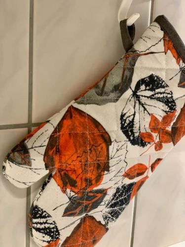 a tie with leaves on it hanging on a wall at Kaupunkikoti Apartments 2-room B32 in Kemi