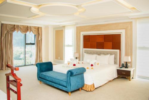 ein Schlafzimmer mit einem großen Bett und einem blauen Stuhl in der Unterkunft Muong Thanh Holiday Con Cuong in Con Cuông