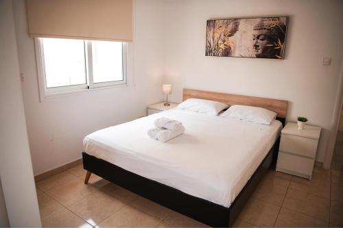 a bedroom with a bed with two towels on it at Mercury Apartment in Livadhia