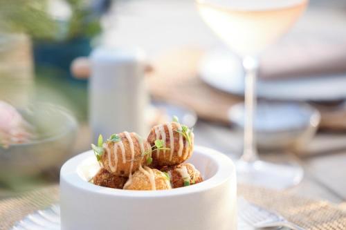 a white bowl of food with a glass of wine at Porto Sani in Sani Beach