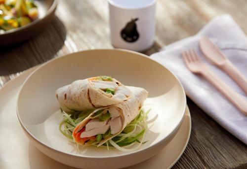 a sandwich in a white bowl on a table at Porto Sani in Sani Beach