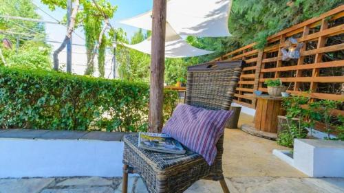 a wicker chair sitting under an umbrella on a patio at Grand Villa in Chimeneas, pool in Chimeneas