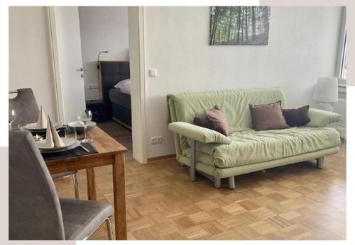 a living room with a green couch and a table at Ferienwohnung Aussichtsreich in Bad Pyrmont