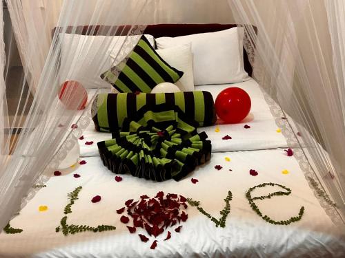 a bed with a cake with the word love on it at Forest Rawana homestay Ella in Ella