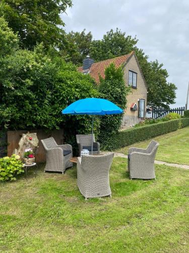 a group of chairs and a table with an umbrella at B&B Aan de Schenkel in Zuid-Beijerland