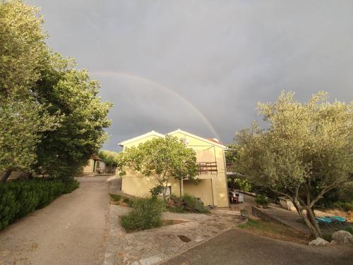 a rainbow in the sky over a house at Beachfront House Nella with full privacy in Jasenice
