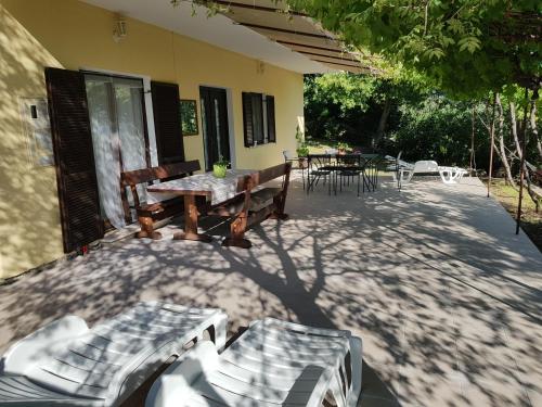 a patio with benches and a table and a table and chairs at Beachfront House Nella with full privacy in Jasenice