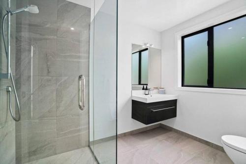 a bathroom with a glass shower and a sink at Lake Living That Wanaka Tree in Wanaka