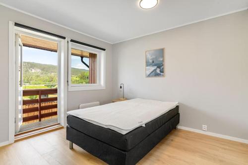 KongsbergにあるFully furnished apartment close to Technology park and Uniのベッドと大きな窓のある寝室
