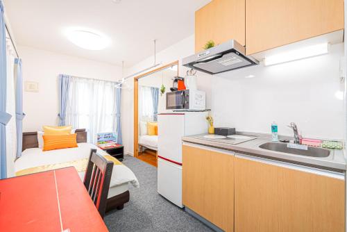 a room with a kitchen with a sink and a bed at KYARA HOTEL 亀戸a in Tokyo