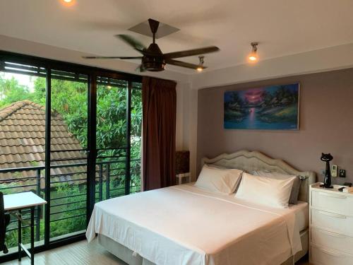a bedroom with a bed and a ceiling fan at Penthouse Crystal Bay Apartments in Ban Lamai