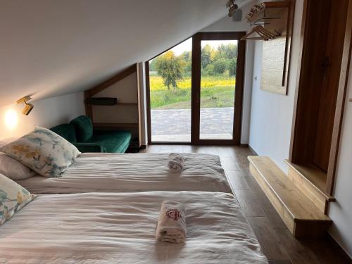 a bedroom with a large bed with slippers on it at Gajówka Pilica 45A in Łęg Ręczyński