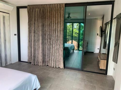 a bedroom with a bed and a sliding glass door at Penthouse Crystal Bay Apartments in Ban Lamai