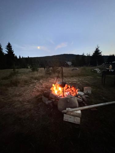 a fire pit in a field at night at CabanA Comandău in Comandău