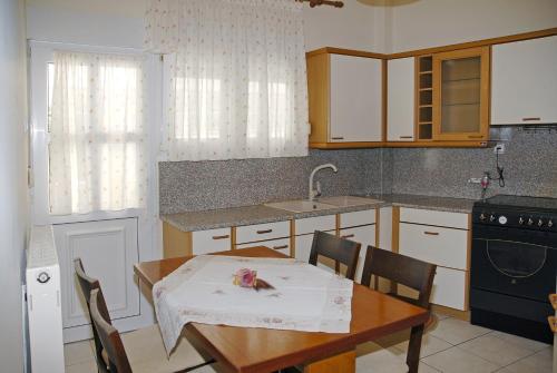 a kitchen with a table and a sink and a table and chairs at Kronos Hotel in Platamonas