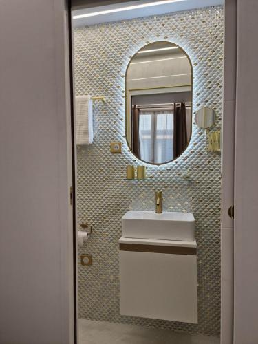 une salle de bain avec un lavabo et un miroir dans l'établissement Appartement - Montmartre, à Paris