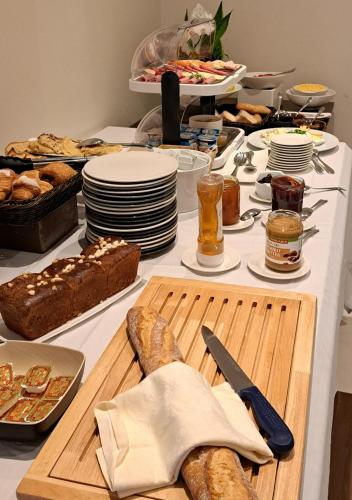 a table with bread and other food on it at HOTEL de la POSTE in Esch-sur-Alzette