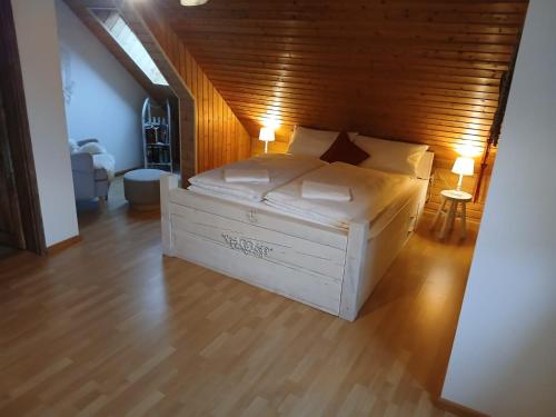 a bedroom with a large white bed with a wooden ceiling at Familienfreundliches-luxus-Bahnwärterhaus in Schiltach
