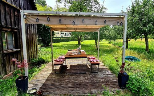 a picnic table under a canopy on a wooden deck at Alexandrowka Wohnen im UNESCO Weltkulturerbe Haus in Potsdam