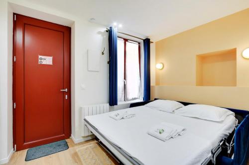 - une chambre avec un lit et une porte rouge dans l'établissement Appartement neuf au coeur de Paris, à Paris