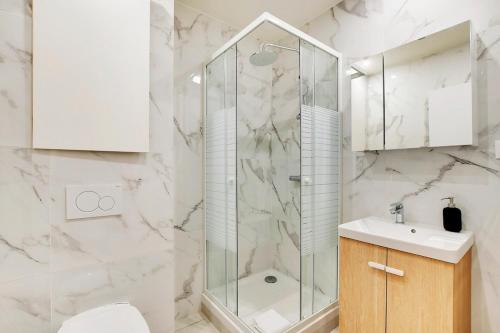 une salle de bain avec douche et lavabo dans l'établissement Appartement neuf au coeur de Paris, à Paris