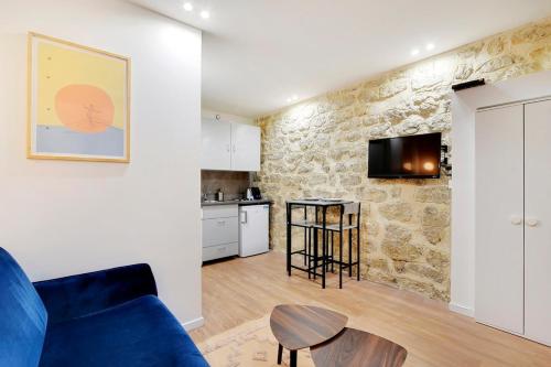 un salon avec un canapé bleu et une cuisine dans l'établissement Appartement neuf au coeur de Paris, à Paris