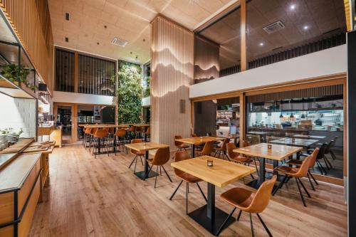an empty restaurant with wooden tables and chairs at ENDEMIT Boutique Hotel & Spa in Horní Bečva