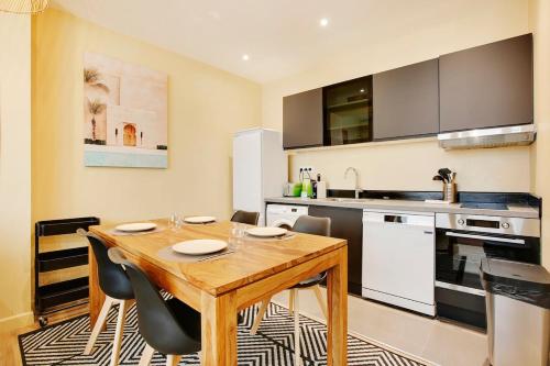 une cuisine avec une table en bois et quelques chaises dans l'établissement Appart lumineux 4 personnes, à Paris
