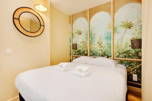 une chambre avec un lit blanc avec un tableau sur le mur dans l'établissement Appart lumineux 4 personnes, à Paris