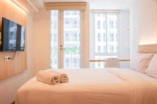 ein Schlafzimmer mit einem Bett mit Handtüchern darauf in der Unterkunft Modern Studio Room at Tokyo Riverside PIK 2 Apartment By Travelio in Rawalembang