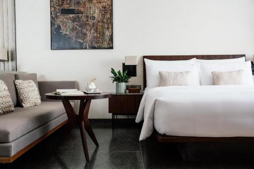 a bedroom with a bed and a couch at Treeline Urban Resort in Siem Reap