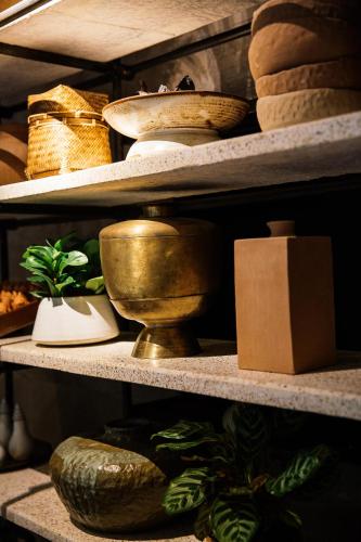 a shelf filled with different types of baskets and other items at Treeline Urban Resort in Siem Reap