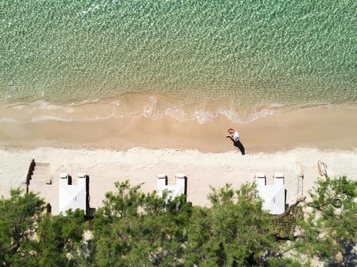 a person standing on a beach near the ocean at Sani Club in Sani Beach