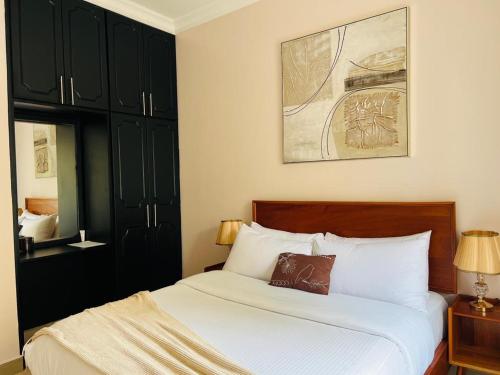 a bedroom with a large bed with black cabinets at Alsander Homes Raspberry in Kampala