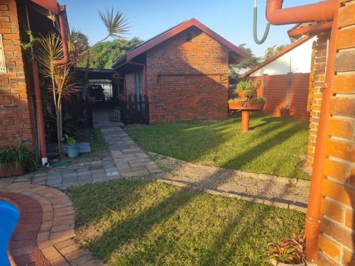 a backyard of a house with a yard withgrass at Cassiandra Place unit 2 in Richards Bay