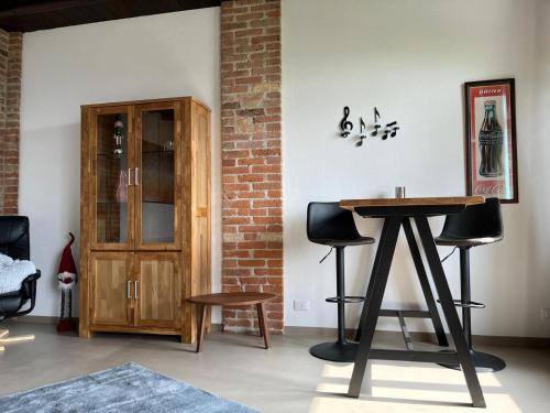 a room with a table and two chairs and a cabinet at Dimora Relax in Costigliole dʼAsti
