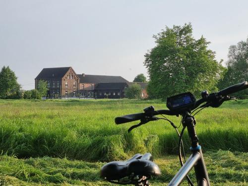 a bike parked in a field with a house in the background at Gutshaus Michelshof in Kevelaer