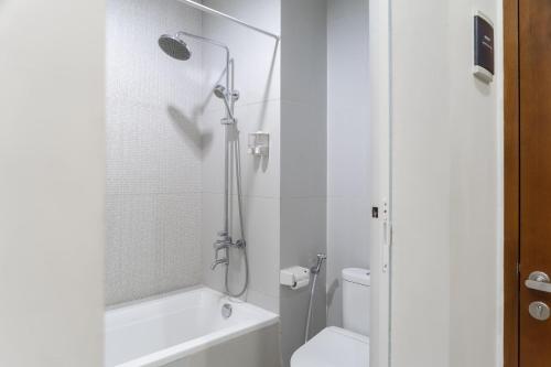 a white bathroom with a shower and a toilet at Cove MK House Senopati in Jakarta