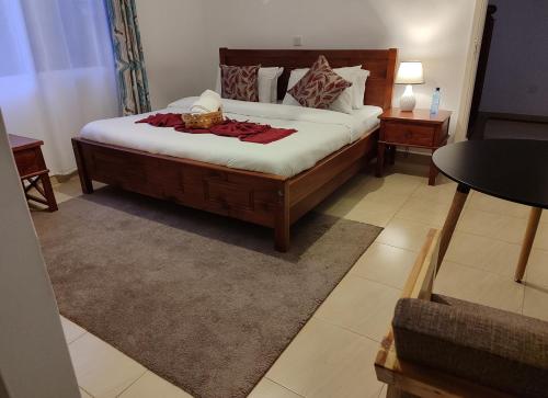a bedroom with a large bed and two night stands at El Tessa garden/serviced apartment in Kisumu
