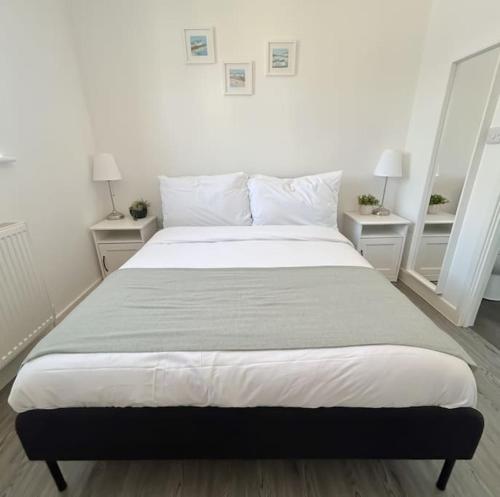 a large bed in a bedroom with two night stands at Wellington Road Apartment 5 in Southtown