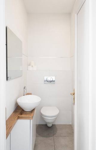 a bathroom with a white toilet and a sink at Adama by Sweett - Keren Hayesod Apartments in Jerusalem