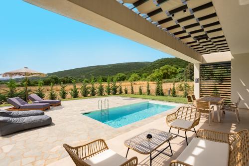 a patio with a pool with chairs and a table at Ioannina Secret Luxury Villas in Ioannina