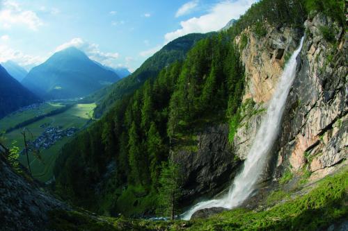 una cascata sul fianco di una montagna di Appartement Aqua a Längenfeld