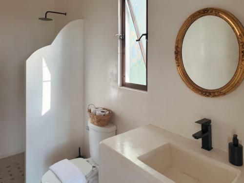 a bathroom with a sink and a mirror and a toilet at COCCOLOBA in Holbox Island