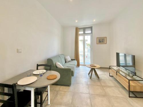 un salon avec un canapé et une table dans l'établissement SweetHome Sully, à Nîmes