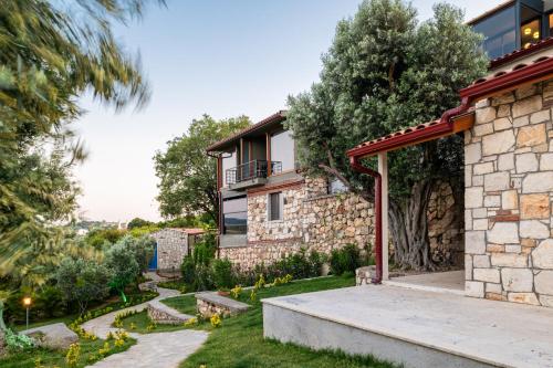 a house with a garden in front of it at Baska Urla Otel in Denizli