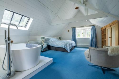 Un baño con bañera y un dormitorio con cama. en Seventeenth century luxury pad near Glastonbury, en Pilton